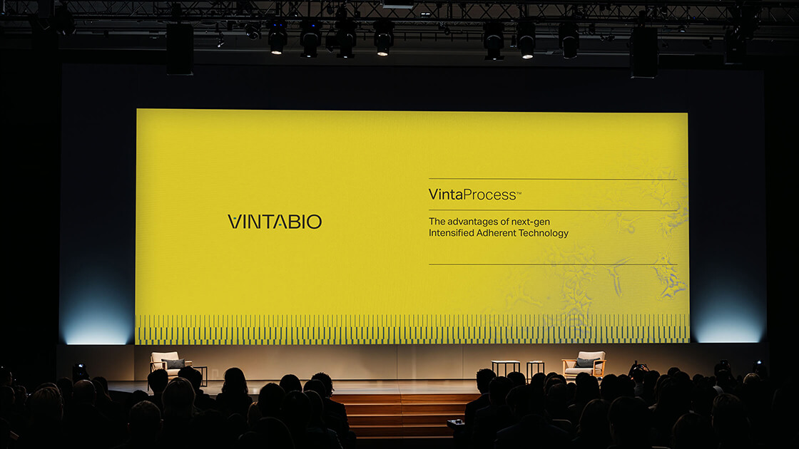Conference slide by Context for VintaBio, showcasing the VintaProcess title, logo, and proprietary cell line visual on a vibrant yellow background as part of their cohesive branding system.